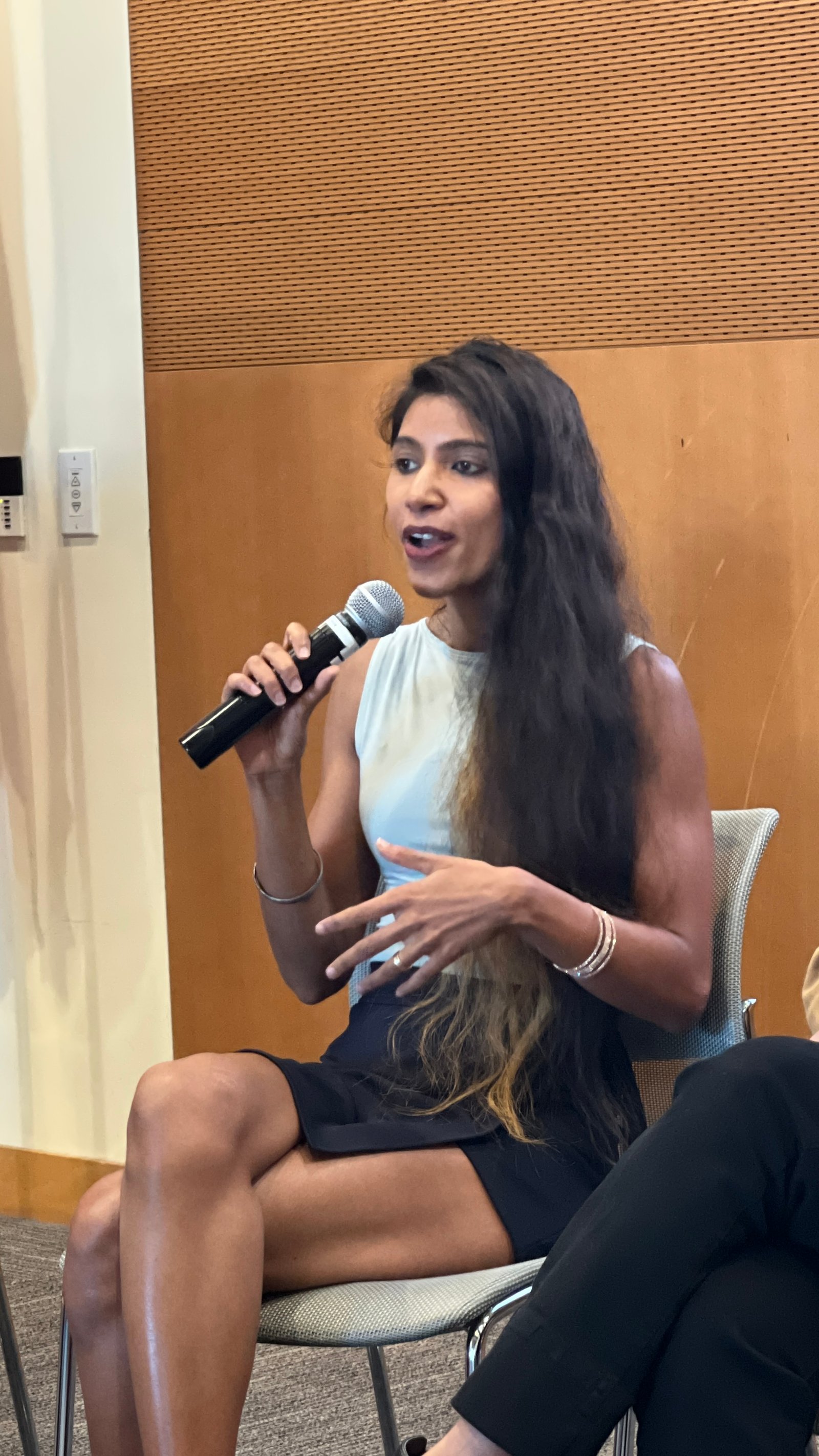 Ishween Kaur speaking with a microphone during a fireside session