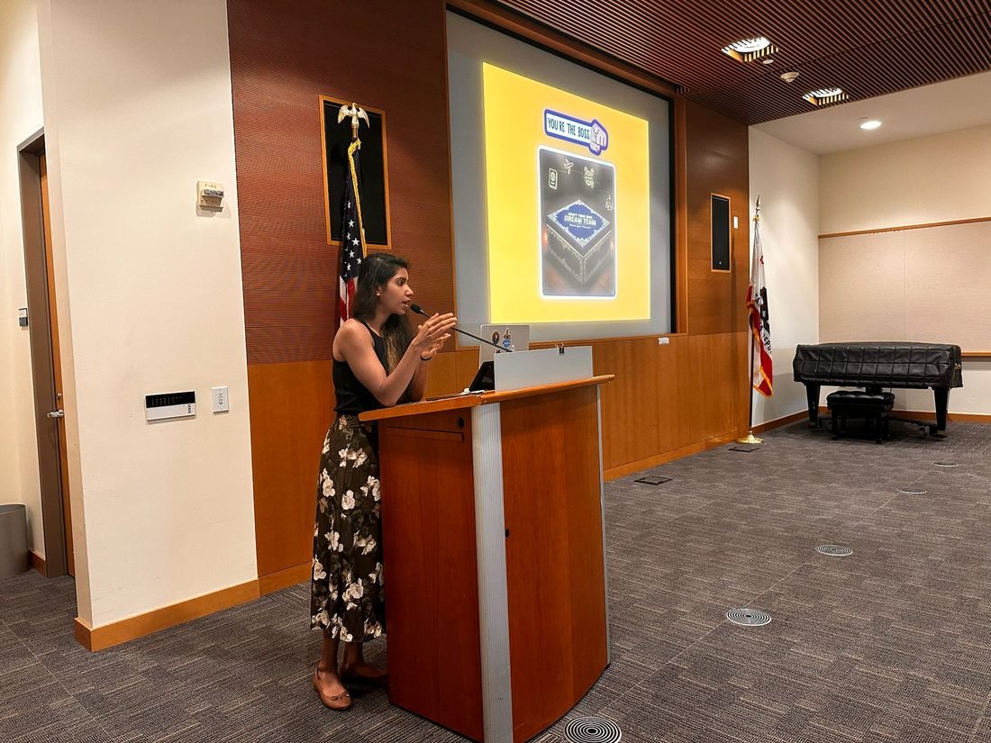 Ishween speaking at a podium during a university session